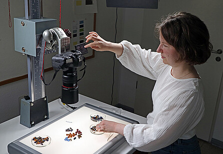 Selina Pohl fotografiert diverse Perlen auf einem Leuchttisch