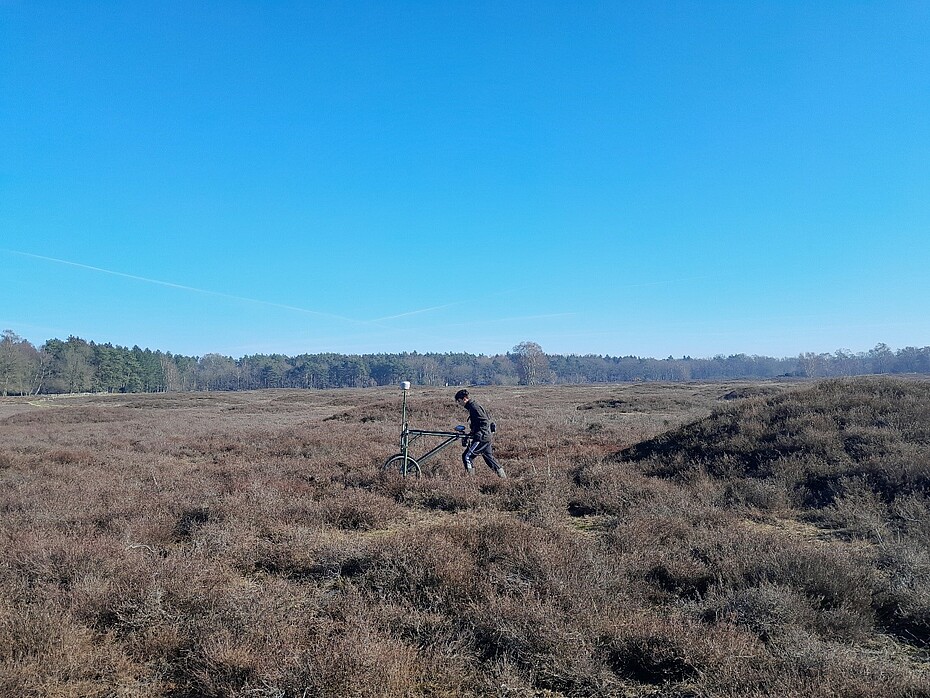 Ein Mitarbeiter schiebt eine Sonde über das Pestruper Gräberfeld in winterlicher Atmosphäre