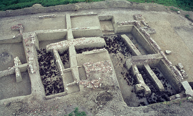 Älteres Grabungsfoto mit resten von Hölzern und vielen Steinen in Grabungsschnitten in der Aufsicht
