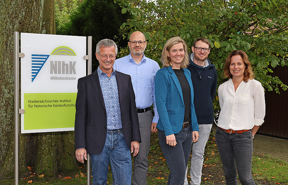 Das Team vor der Aussenwerbung des Instituts