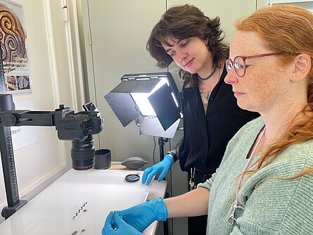 Two staff members from the institute are photographing the finds.